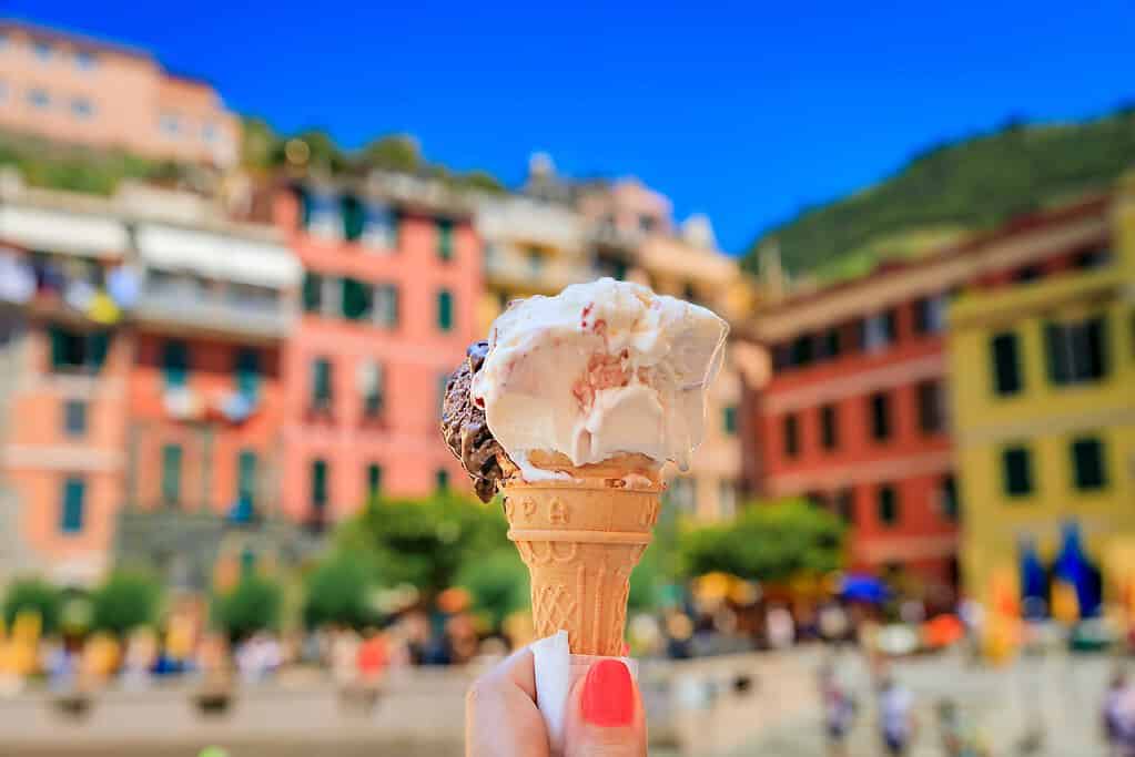 Holding gelato in front of colorful buildings in Italy